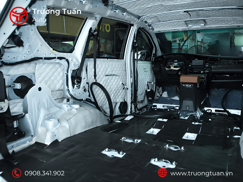 Kỹ thuật viên đang dán vật liệu cách âm chuyên dụng vào sàn xe ô tô